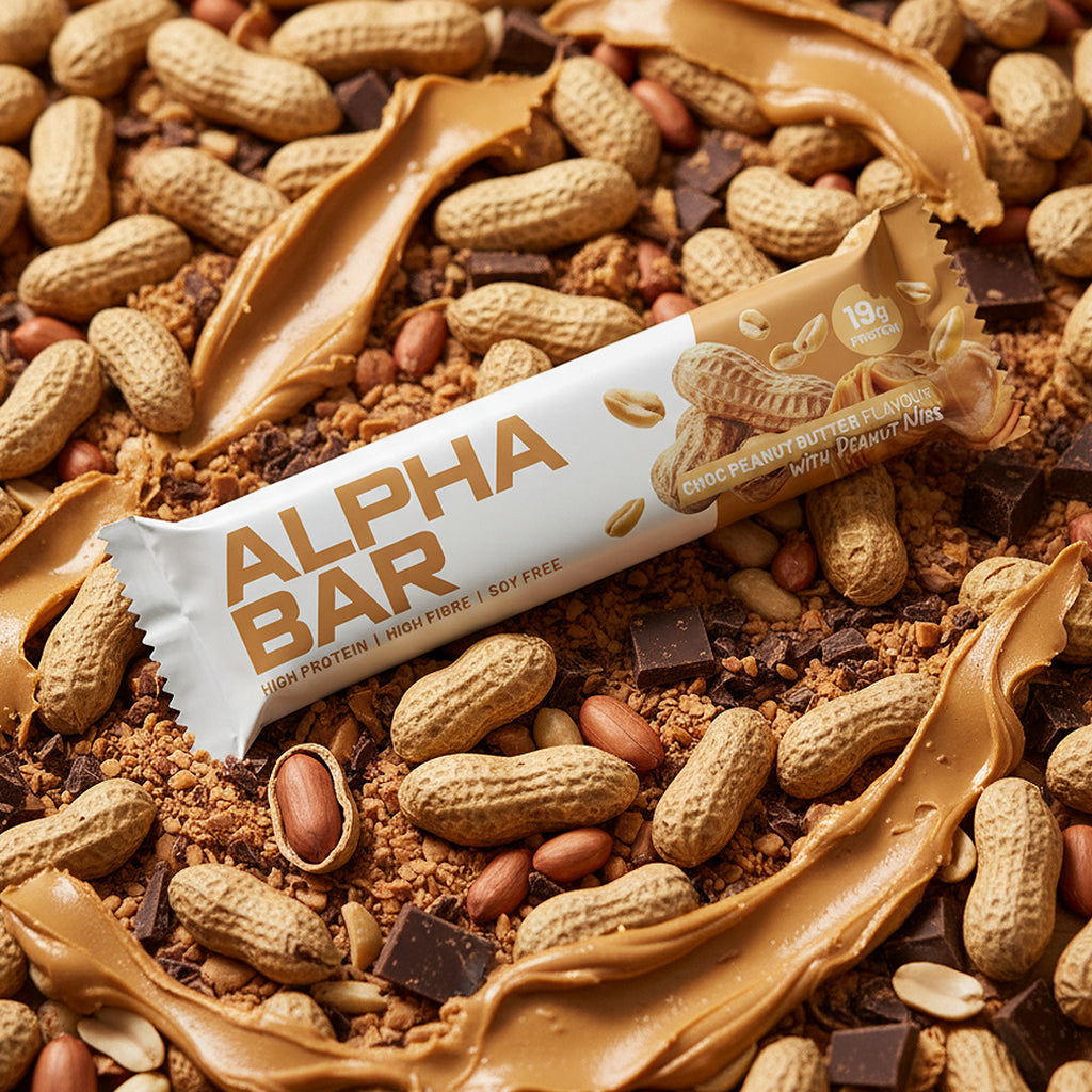 Alpha Bar protein bar surrounded by peanuts and chocolate pieces