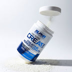 Container of Creatine supplement with powder spilling out on a white background